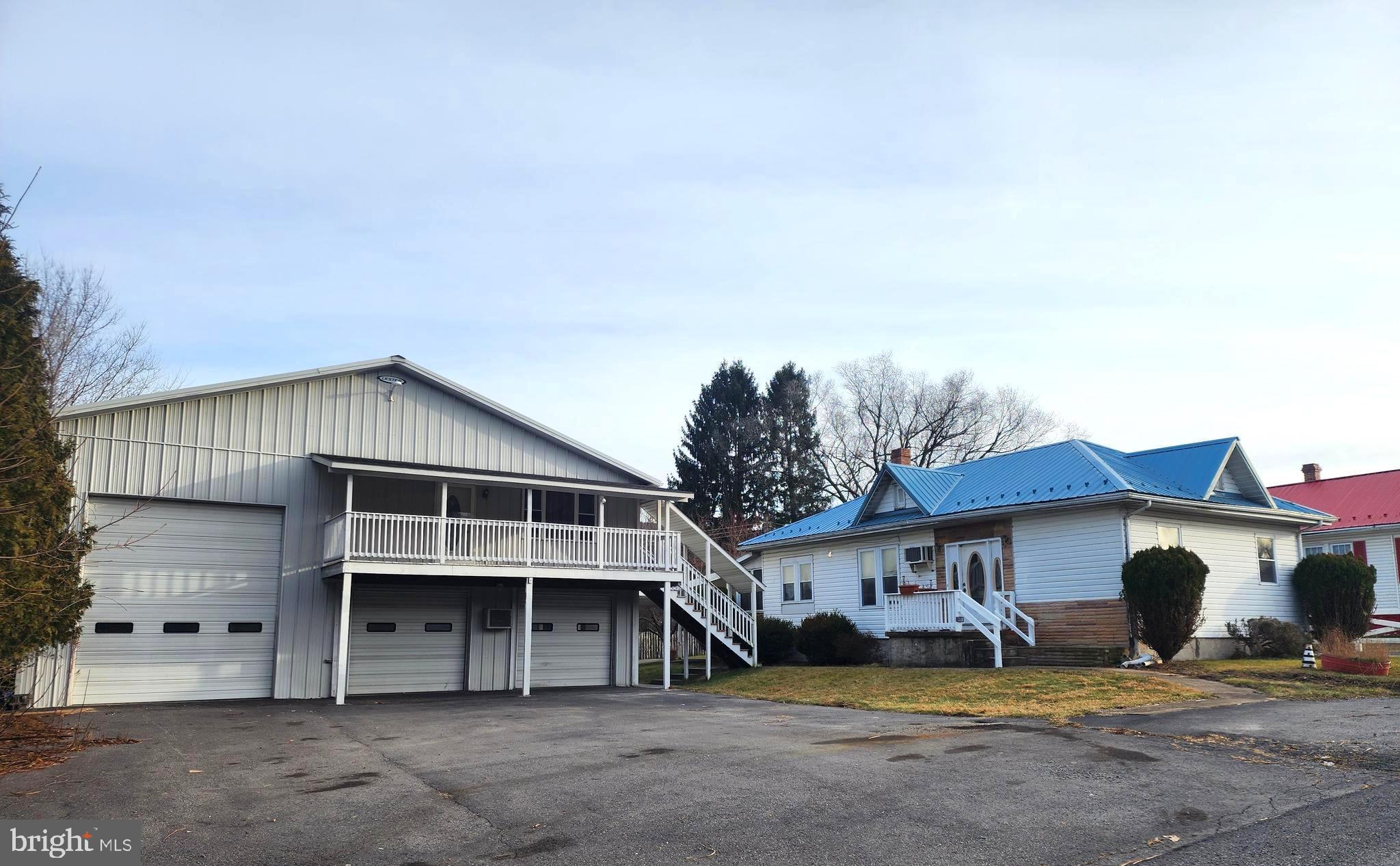 a view of a house with a yard and large tree