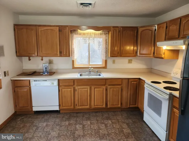 a kitchen with kitchen island granite countertop a sink cabinets and stainless steel appliances