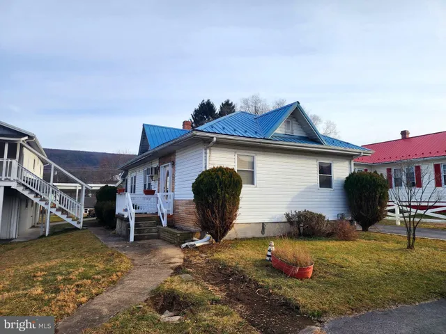 a view of a house with backyard and sitting area