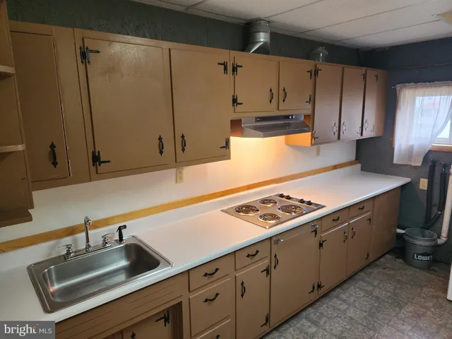 a kitchen with granite countertop a sink stove and cabinets