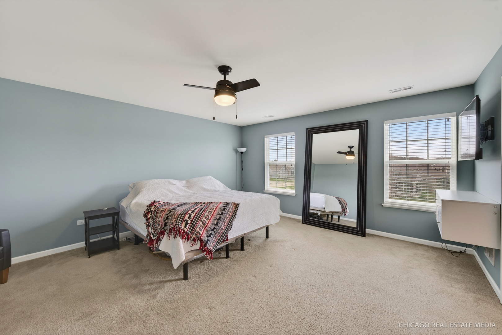 295 Monarch Lane Volo, IL 60020 - Photo 16 of 36 a spacious bedroom with a large bed and a chandelier