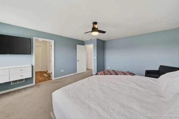 a bedroom with a bed and a flat tv screen on dresser