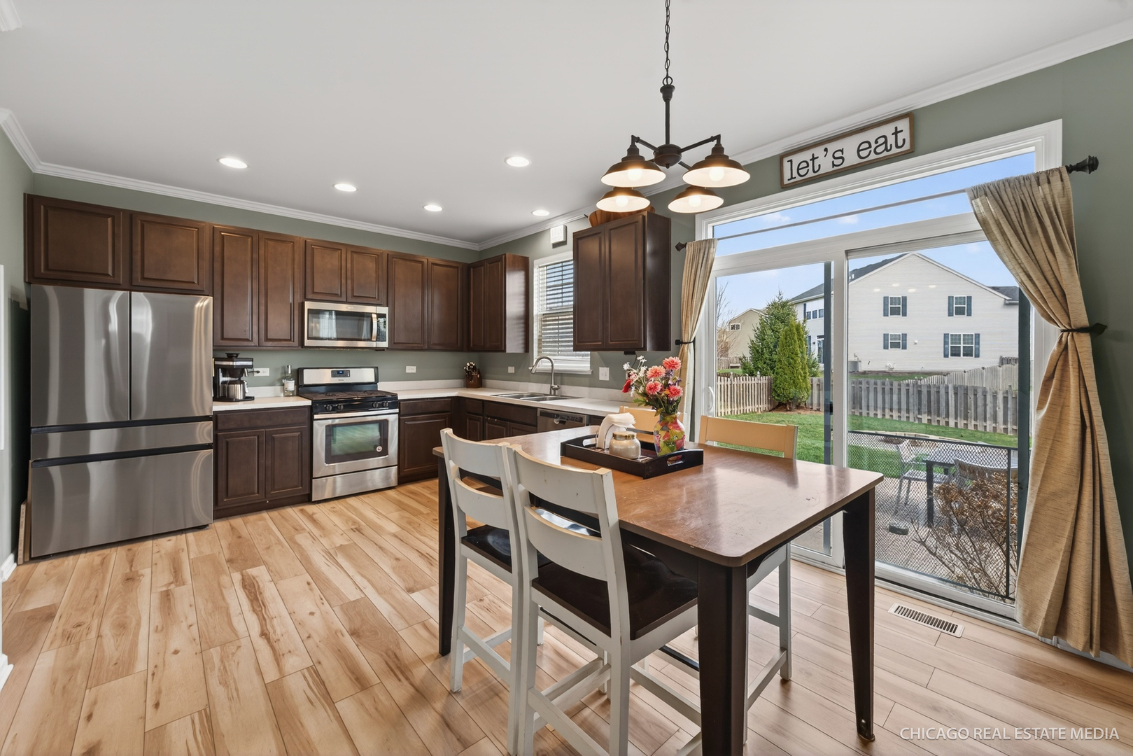 295 Monarch Lane Volo, IL 60020 - Photo 10 of 36 a kitchen with a table chairs stainless steel appliances and cabinets