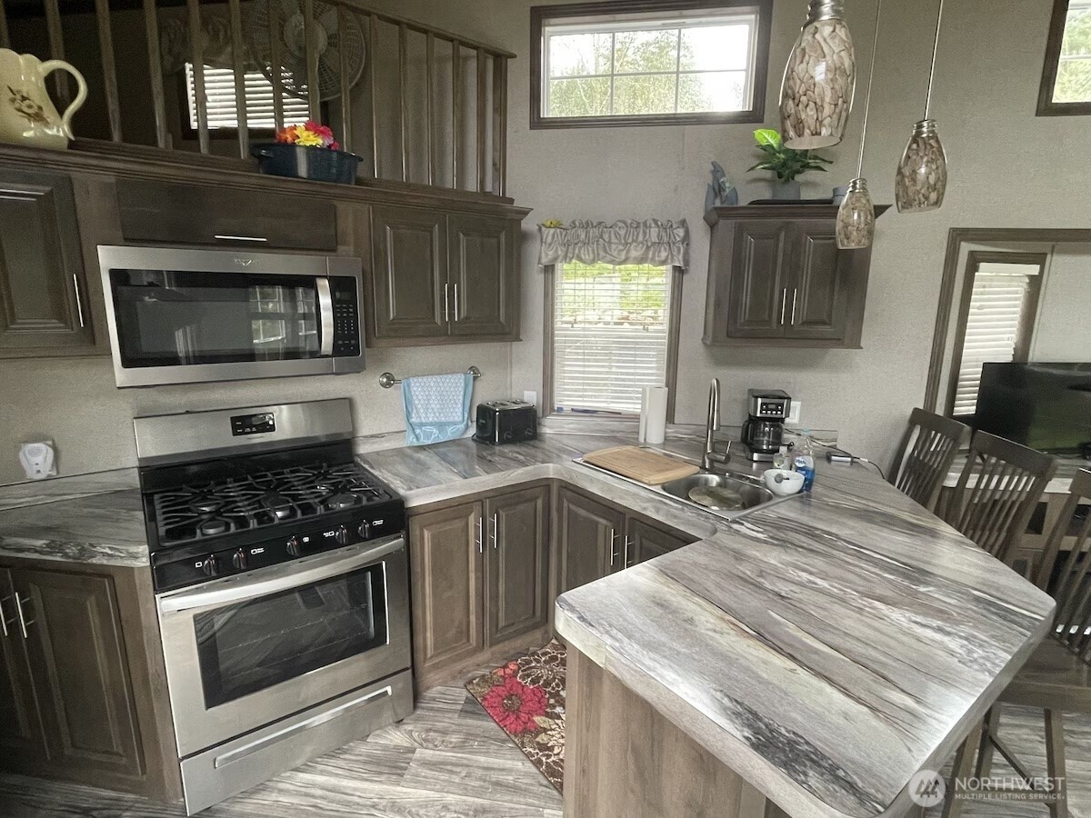 50 North Rustic Ridge Drive Lilliwaup, WA 98555 - Photo 11 of 40 a kitchen with a stove a sink and a microwave