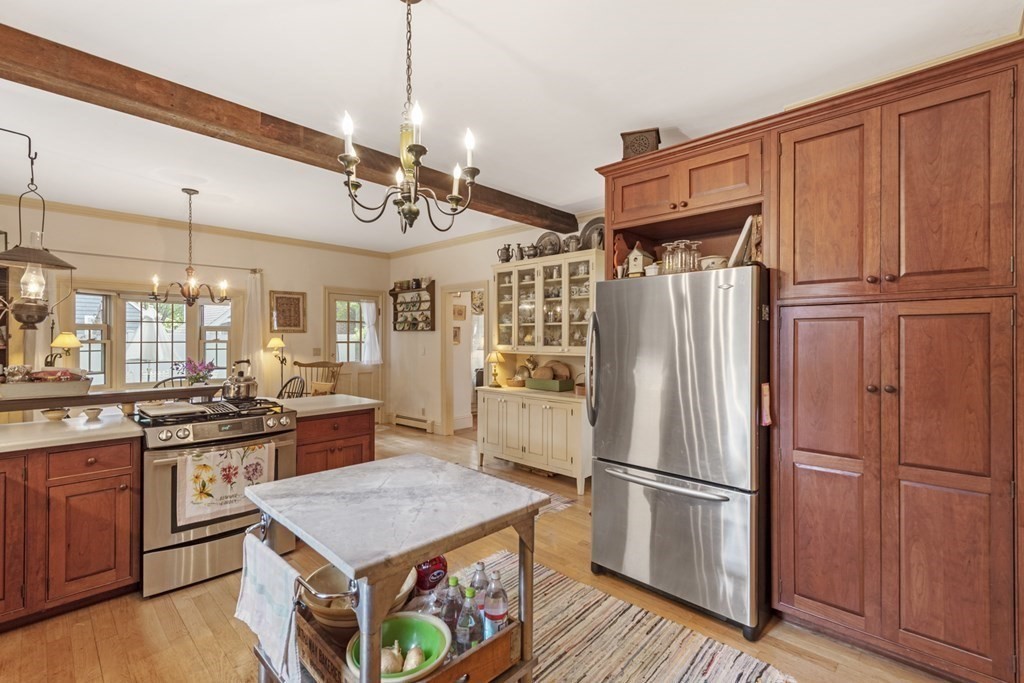 42 Willow Street Reading, MA 01867 - Photo 7 of 35 a kitchen with kitchen island a counter top space a sink stainless steel appliances and cabinets