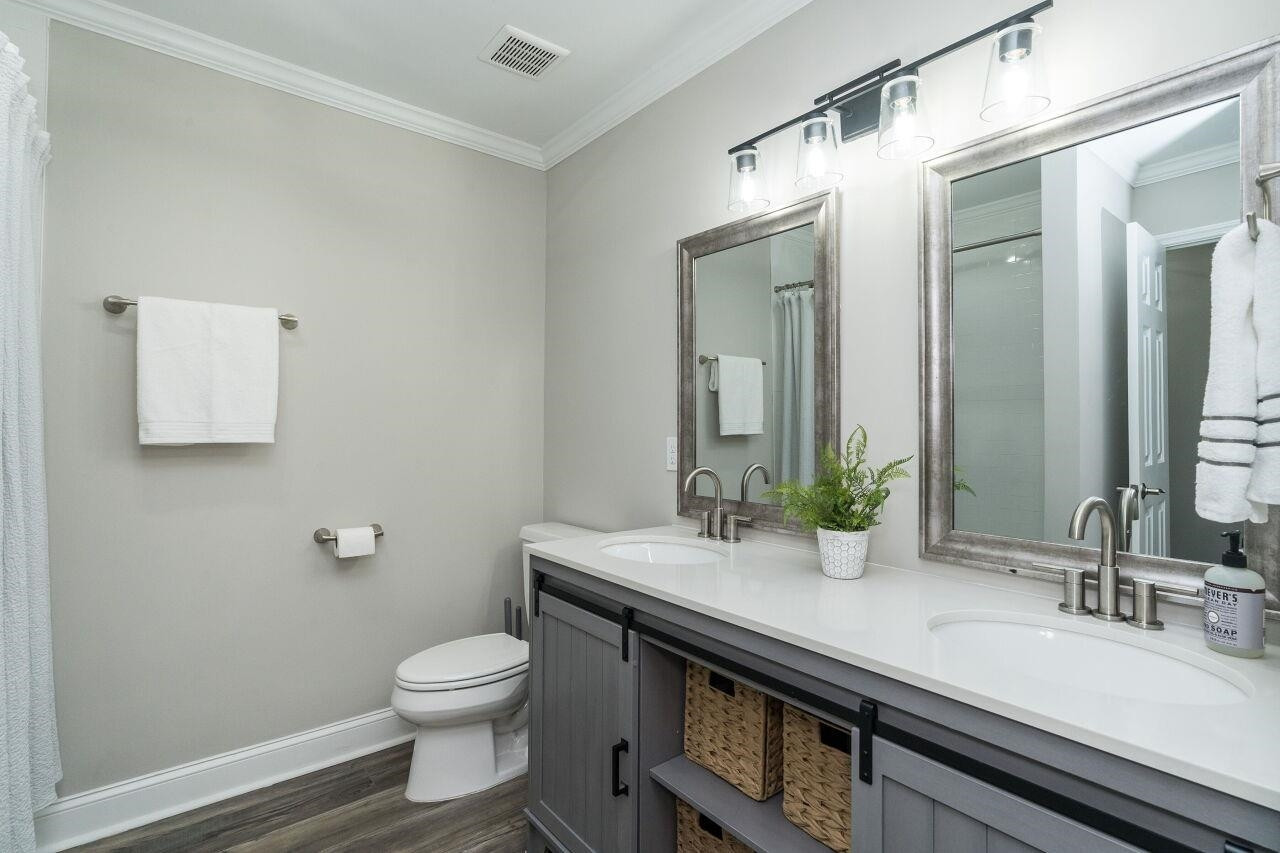 9801 Pine Meadow Lane Raleigh, NC 27615 - Photo 14 of 43 a bathroom with a granite countertop sink a toilet and a mirror