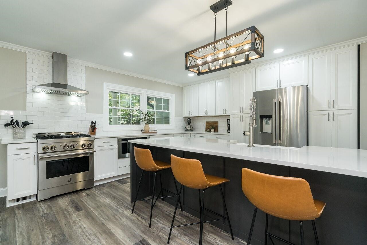 9801 Pine Meadow Lane Raleigh, NC 27615 - Photo 7 of 43 a kitchen with stainless steel appliances granite countertop a stove a refrigerator a sink dishwasher a dining table and chairs with wooden floor