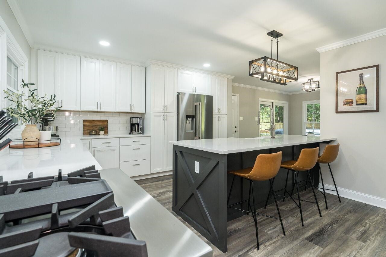 9801 Pine Meadow Lane Raleigh, NC 27615 - Photo 8 of 43 a kitchen with a dining table chairs sink and white cabinets