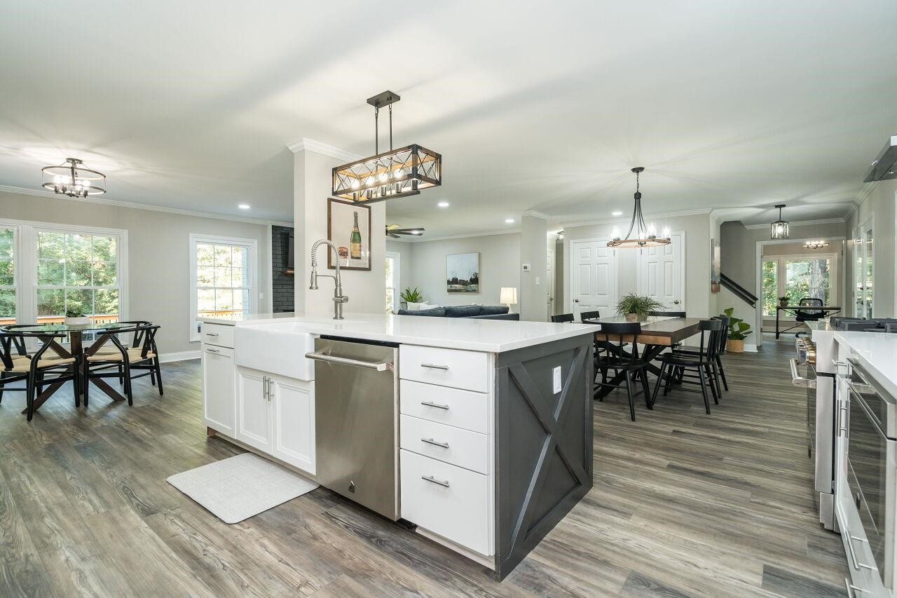 9801 Pine Meadow Lane Raleigh, NC 27615 - Photo 9 of 43 a large kitchen with kitchen island a sink a center island a stove and a dining table view