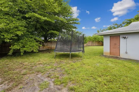 a backyard of a house with plants and wooden fence