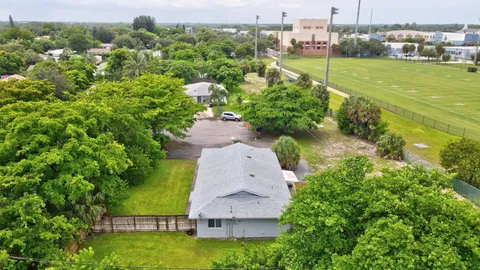 an aerial view of a house with a yard and lake view