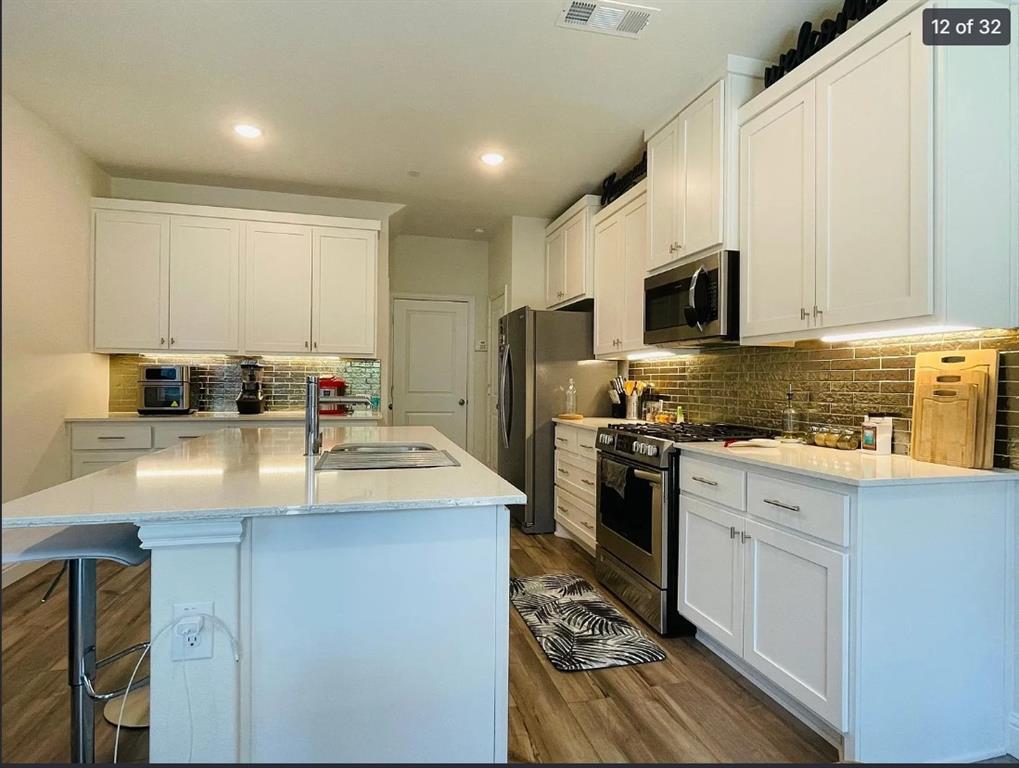 1009 Emil Place Allen, TX 75013 - Photo 12 of 31 a kitchen with kitchen island granite countertop a sink a counter top space appliances and cabinets