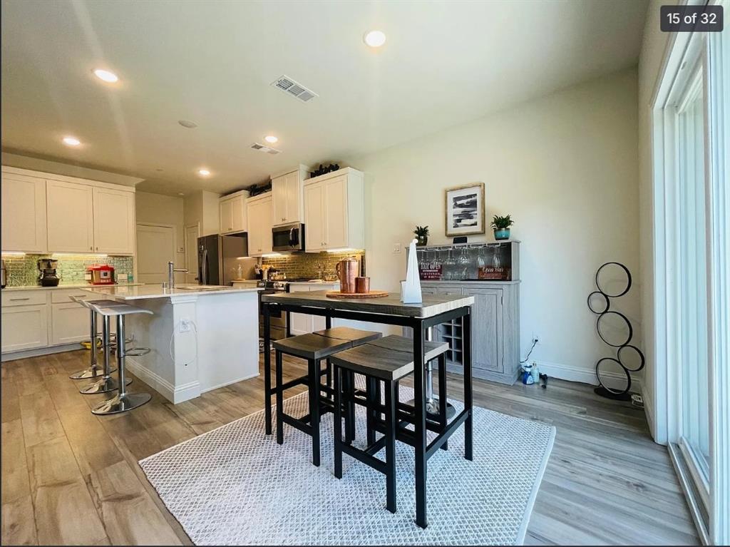 1009 Emil Place Allen, TX 75013 - Photo 15 of 31 a kitchen with a table chairs refrigerator and microwave