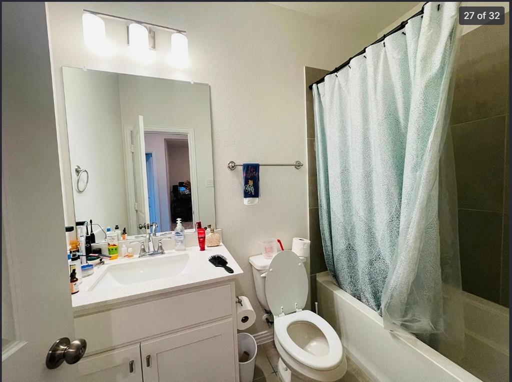 1009 Emil Place Allen, TX 75013 - Photo 26 of 31 a bathroom with a sink a toilet and shower curtain