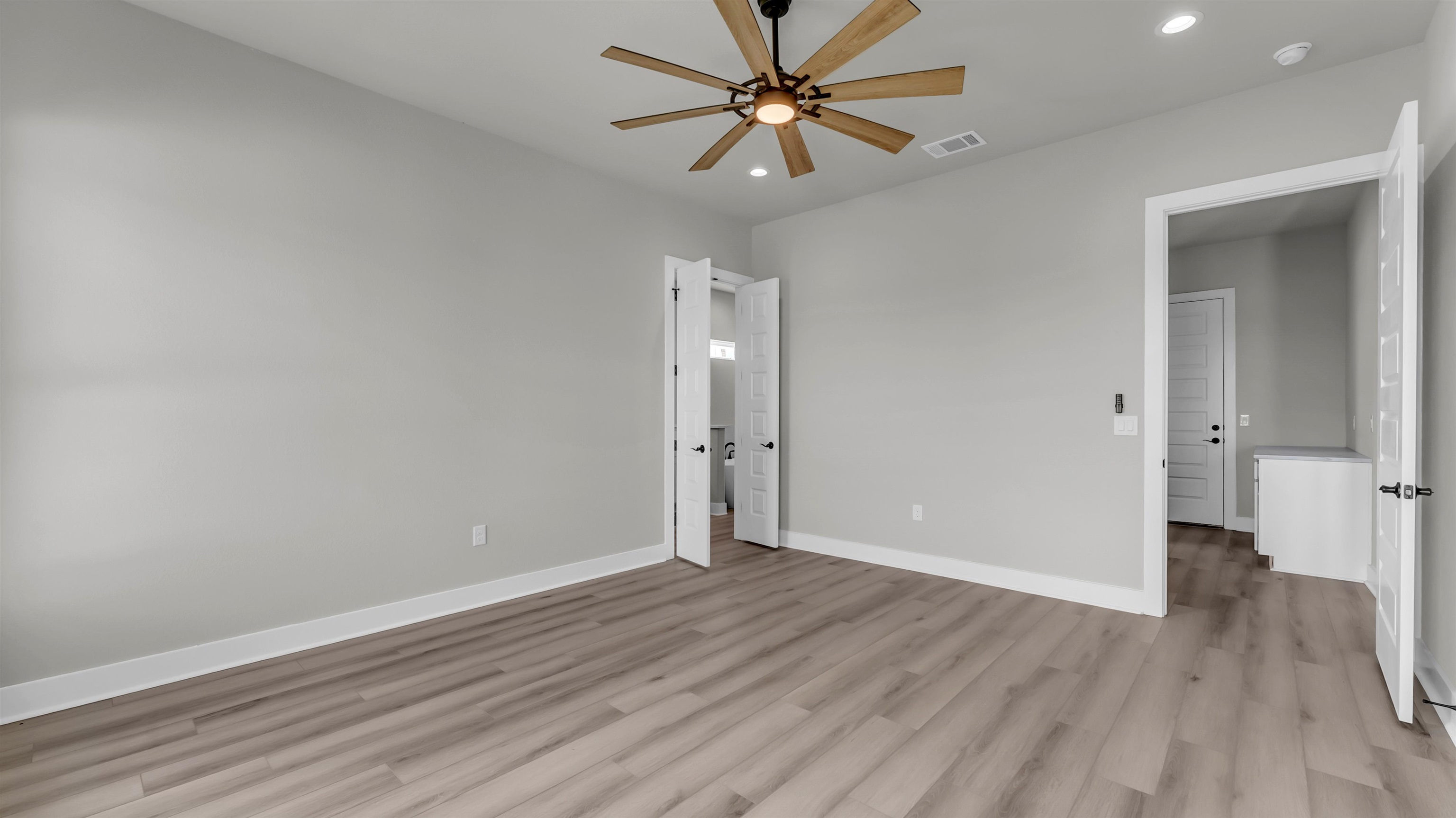 373 Prarie Point Road Bertram, TX 78605 - Photo 11 of 25 an empty room with wooden floor and a ceiling fan