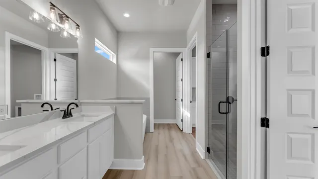a en suite bathroom with a sink mirror and a shower