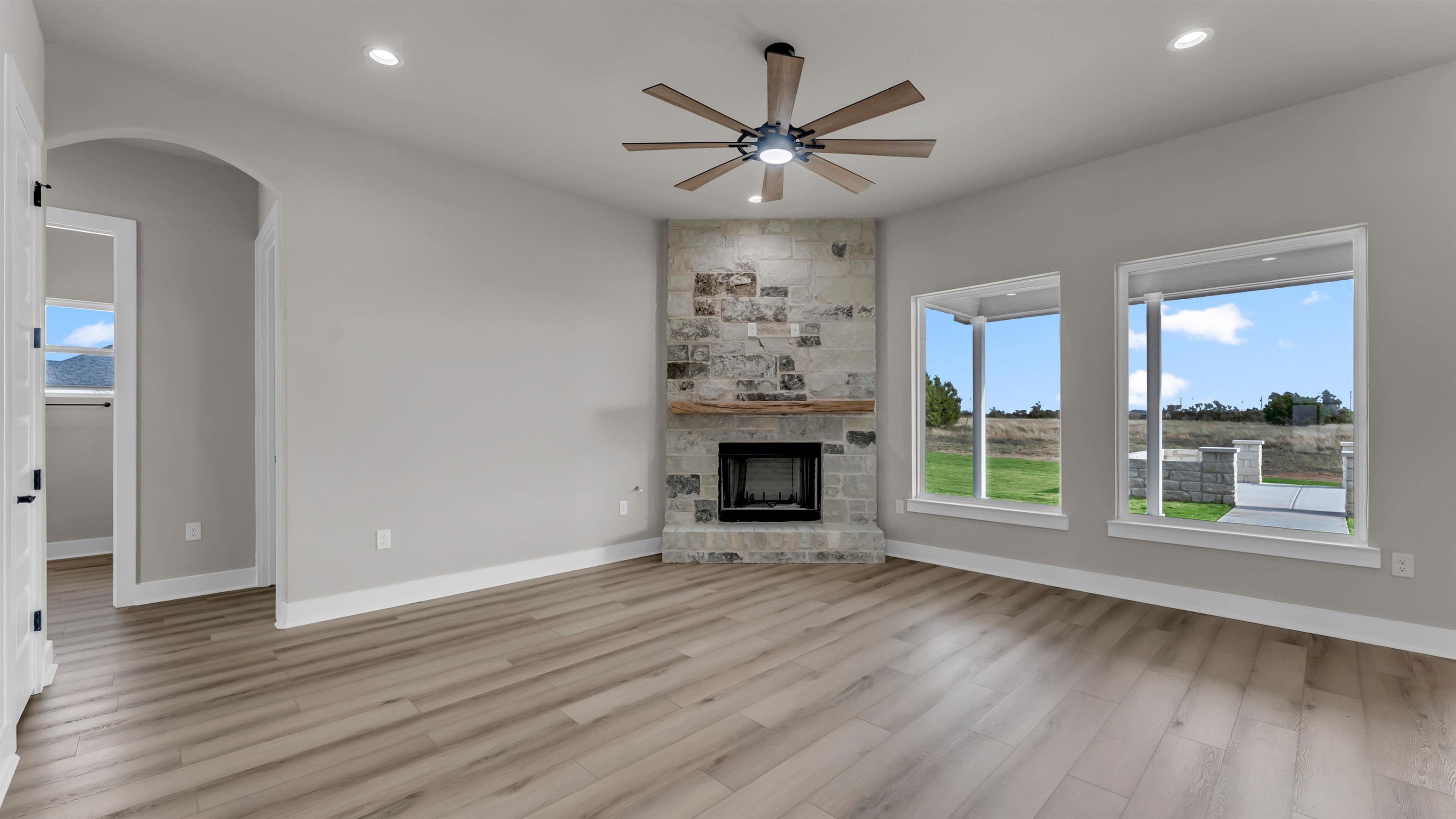 373 Prarie Point Road Bertram, TX 78605 - Photo 3 of 25 an empty room with windows a fireplace and wooden floor