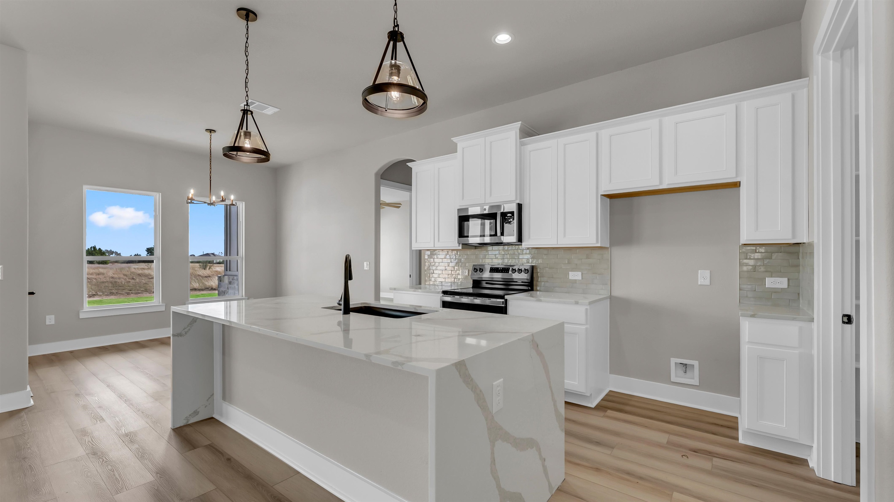373 Prarie Point Road Bertram, TX 78605 - Photo 5 of 25 a kitchen with stainless steel appliances granite countertop a sink a stove and a wooden floors
