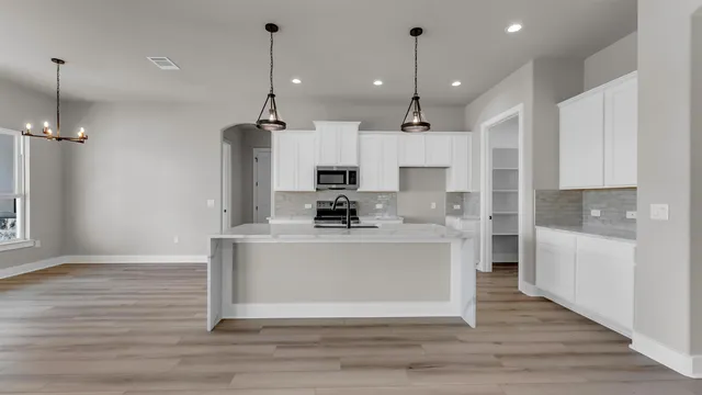 a view of kitchen with stainless steel appliances granite countertop cabinets and wooden floor