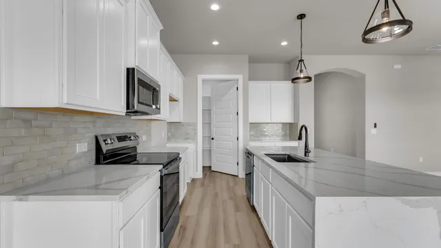 a kitchen with stainless steel appliances granite countertop a sink stove and refrigerator