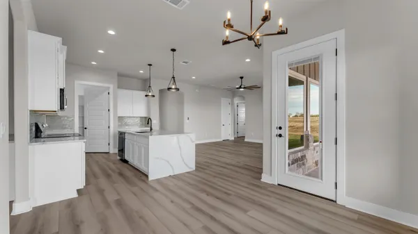 a large kitchen with white cabinets and stainless steel appliances