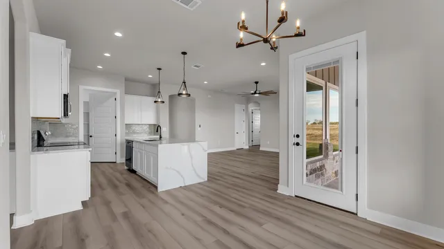 a large kitchen with white cabinets and stainless steel appliances