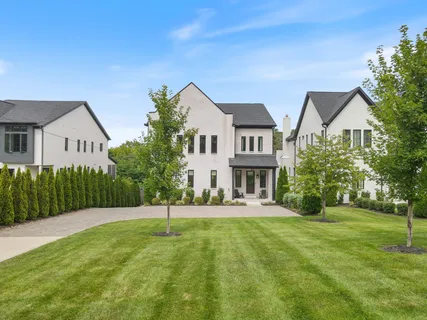 a front view of a house with a yard and trees