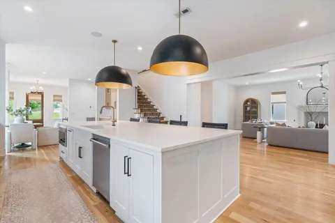 a kitchen with a stove a chimney a sink and a wooden floors