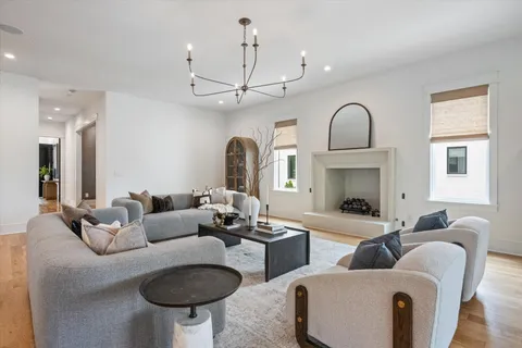 a living room with furniture a fireplace and a chandelier