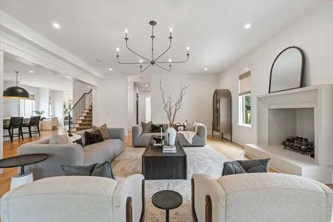 a living room with furniture a large window and a chandelier