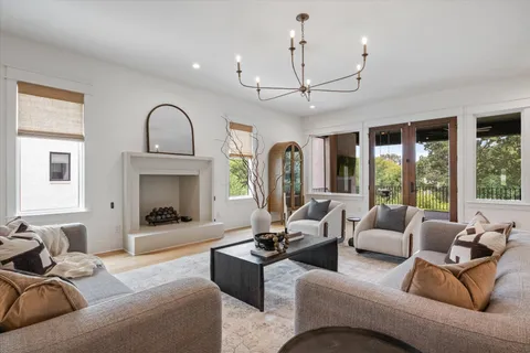 a living room with furniture a large window and a fireplace