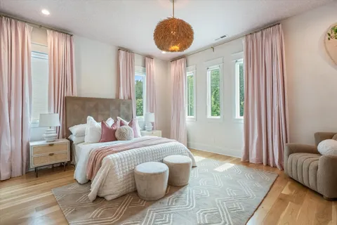 a spacious bedroom with a bed and a chandelier