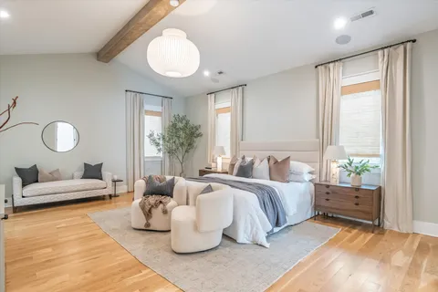 a bedroom with furniture and a large window