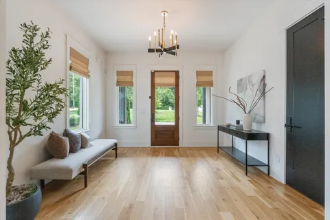 a living room with furniture a window and a chandelier