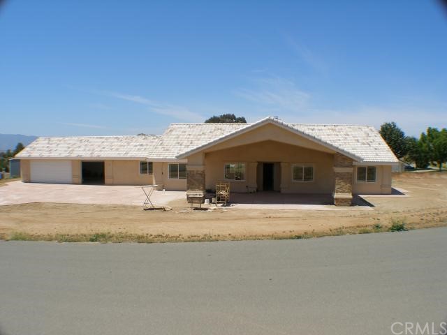17031 Riverside Avenue Riverside, CA 92508 - Photo 1 of 1 Standing across the street on Riverside looking West. Beautiful custom hand set rock fascia at portico and custom designed and stained concrete on driveway and walk way all around the house.