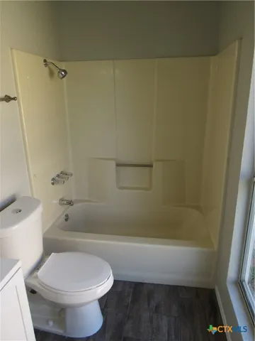 a white toilet sitting next to a bath tub