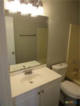 a bathroom with a sink mirror and toilet