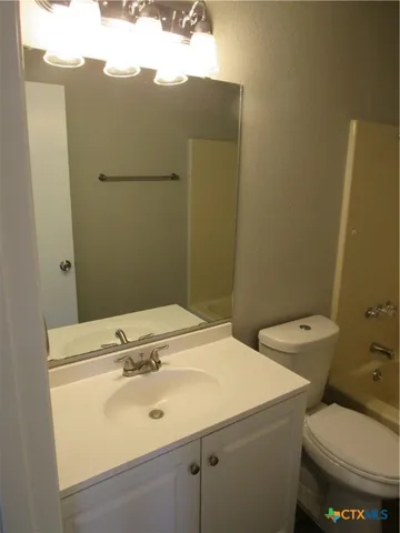 a bathroom with a sink mirror and toilet