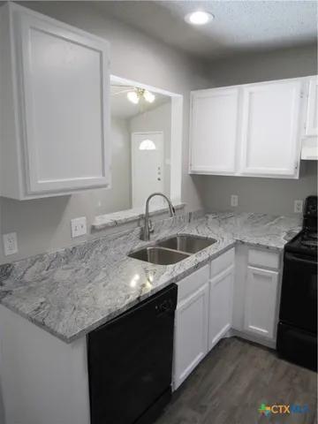 a kitchen with granite countertop a sink and cabinets