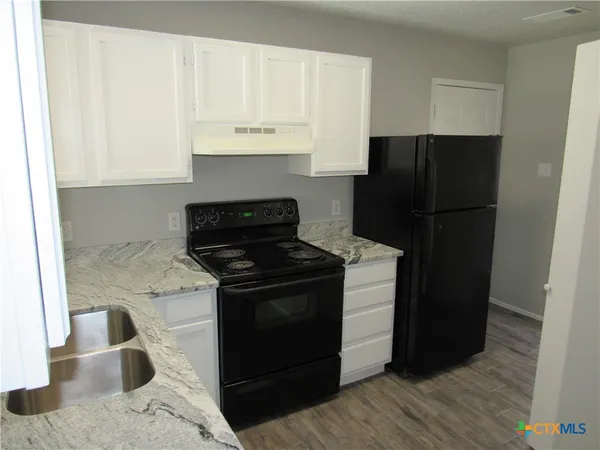 a kitchen with a sink stove and refrigerator