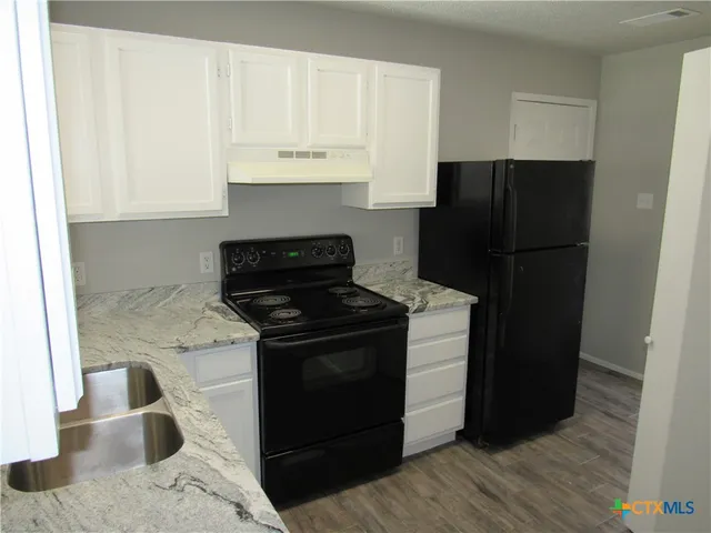 a kitchen with a sink stove and refrigerator