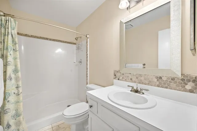 a bathroom with a sink toilet mirror and shower