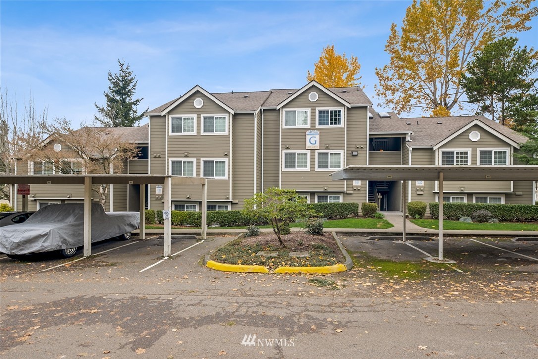 1830 South 284th Lane, Unit G102 Federal Way, WA 98003 - Photo 1 of 27 a view of a white house with a yard and plants