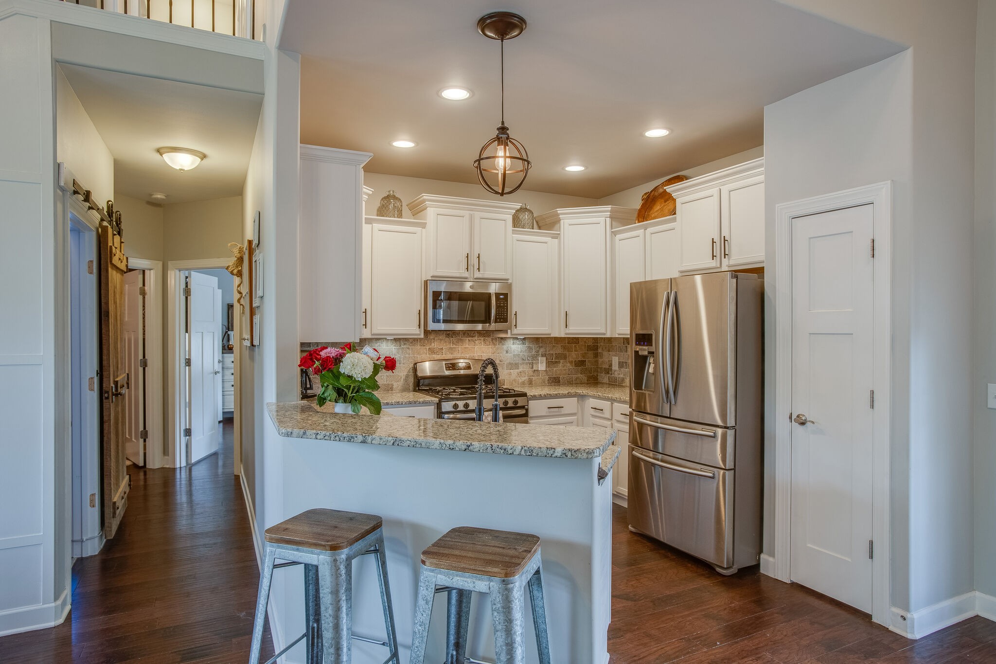 1073 Golf View Way Spring Hill, TN 37174 - Photo 11 of 34 a kitchen with stainless steel appliances a refrigerator sink and wooden floor