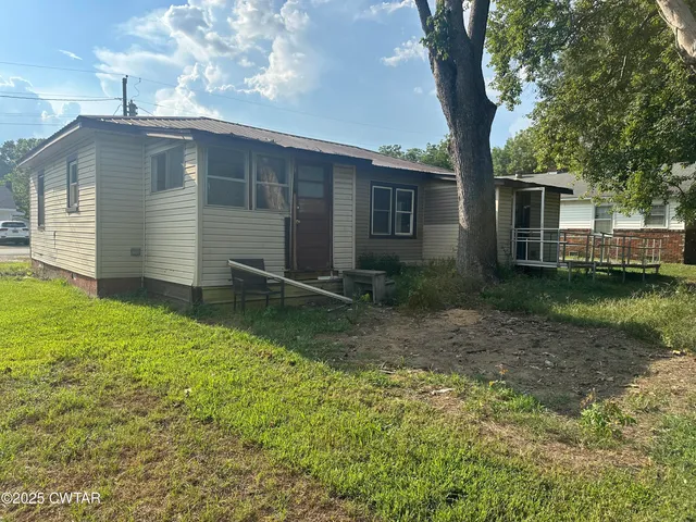 a backyard of a house with barbeque oven table and chairs