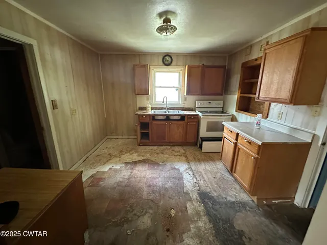a room with kitchen island a sink a stove and a window