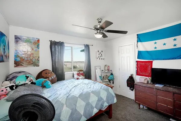 a bedroom with a bed dresser and flat screen tv