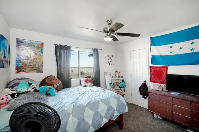 a bedroom with a bed dresser and flat screen tv