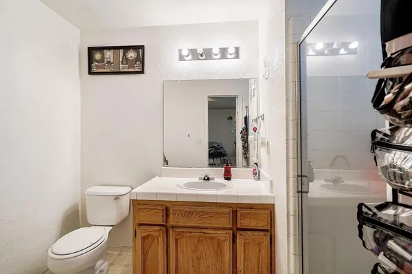 a bathroom with a sink a toilet and a mirror