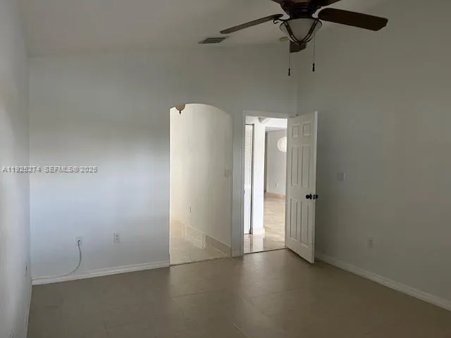 an empty room with fan and entrance